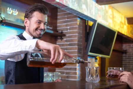 Bartender is making cocktail at bar counterの写真素材