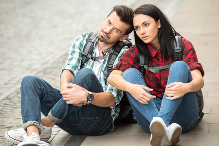 Young tourists are sitting on the ground, resting.の写真素材
