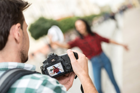 Man is taking picture of girlfriend on tourist journey.の写真素材