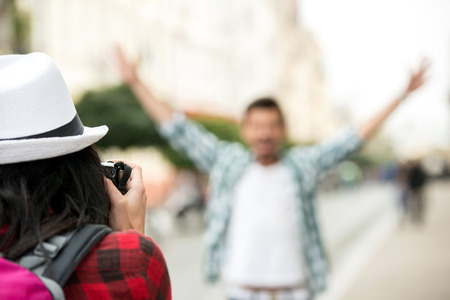 Woman is taking picture of boyfriend on tourist journey.の写真素材