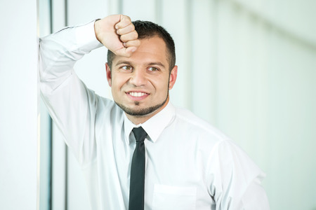 Portrait of young businessman, smiling.