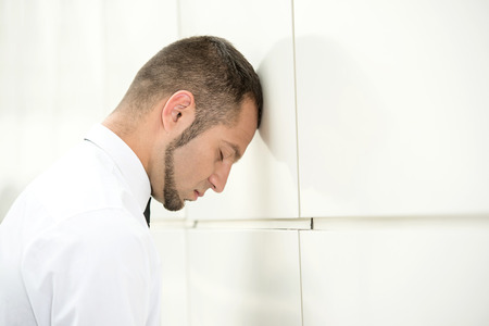 Unemployed man, stressed for there is no work. Beats head against wall.