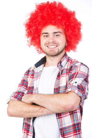 Young football fan with a wig on his head, isolated on white.の写真素材