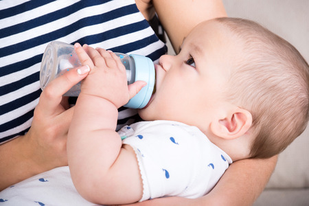 Portrait of a little boy, mother is feeding him. Close-up.の写真素材