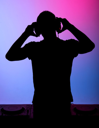 Silhouette of a man with earphones on the colored background.の写真素材