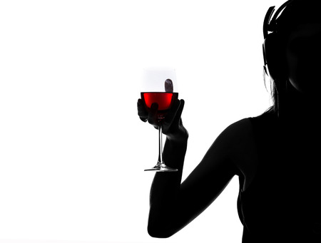 Portrait of a young woman who is holding a glass of wine on the white background.の写真素材