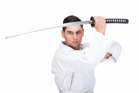 A martial arts man is standing with a sword, isolated on the white background.