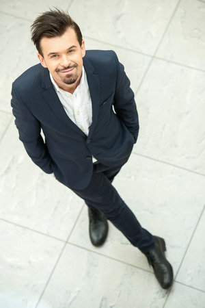 Portrait of young, smiling businessman. Top view. He is looking at the camera.の写真素材