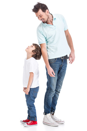 Portrait of happy father and his little son, on the white background. They are looking at each other.の写真素材