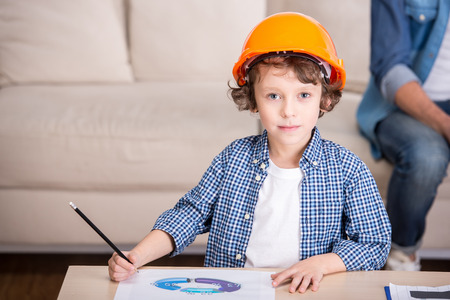 Portrait of a little boy with helmet on head, is drawing.の写真素材