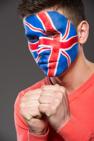 Young man with flag painted on his face to show UK support in sports.の写真素材