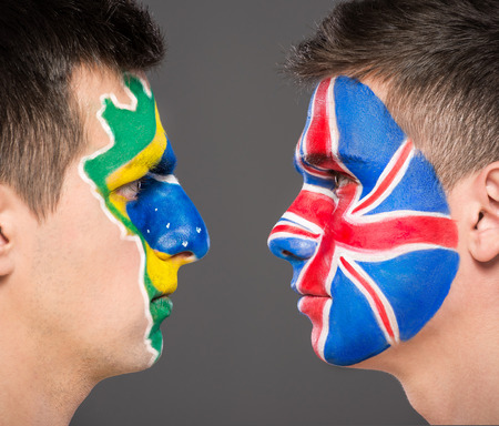 Portrait of two men with painted flags on their faces. Brazil and the United Kingdom.の写真素材
