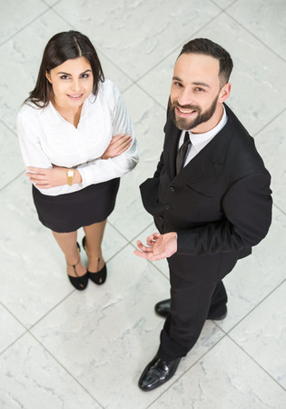 Top view of two business people at work are looking at the camera.の写真素材
