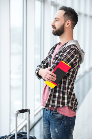 Young man with a suitcase and passport ready to travel.の写真素材