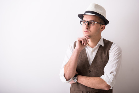 Portrait of  young confident man is wearing a hat on grey background.の写真素材