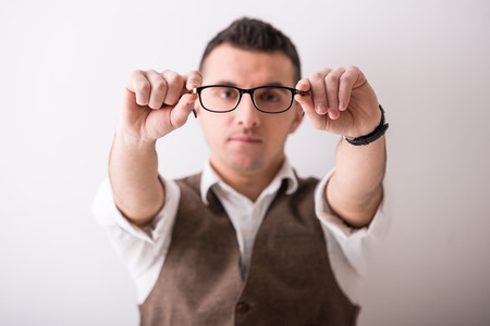 Portrait of  young confident man with glasses on grey .の写真素材