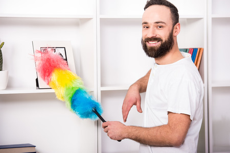 Young man is doing some cleaning work in the house.
