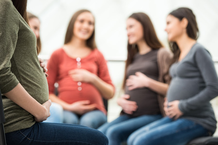 Happy pregnant women are talking together at antenatal class at the hospital.の写真素材