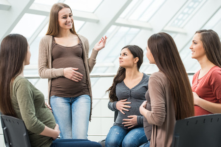 Happy pregnant women are talking together at antenatal class at the hospital.の写真素材