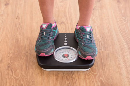 Close-up of woman's legs on the scales.の写真素材