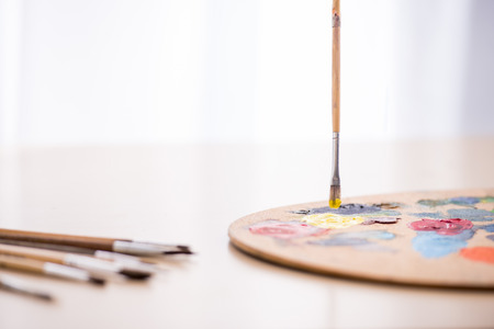 Close-up image of brushes, paints and palette on the table.の写真素材