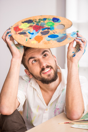 Close-up of young artist with mix color oil painting on palette.の写真素材