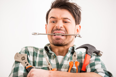 Portrait of young man is doing repair at home with tools.の写真素材
