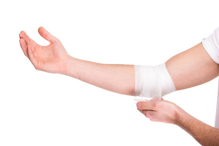 Close-up hand of man, injured painful elbow with white bandage.の写真素材