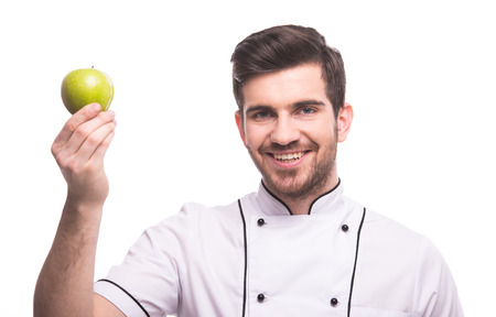 Handsome chef is holding an apple, isolated on white background.の写真素材