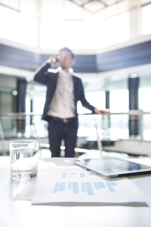 Focus on the things on the table. Blurred man on background.の写真素材