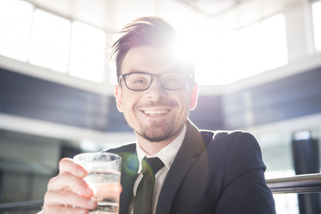 Young businessman is holding a glass of water.の写真素材