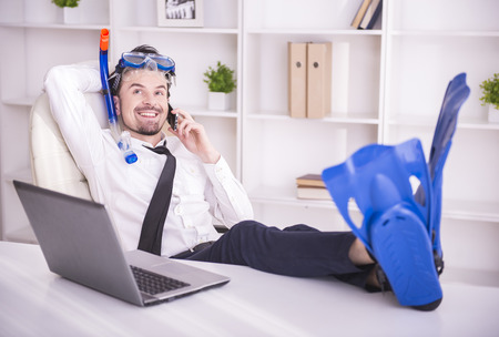 Happy businessman is working in office is wearing in fins.の写真素材