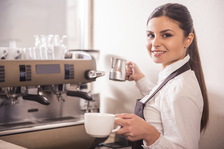 Smiling female barista is preparing coffee at coffee shop.の写真素材