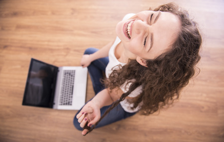 Funny image of a young woman from laptop. High angle view.の写真素材