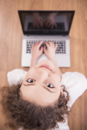 Funny image of a young woman from laptop. High angle view.の写真素材