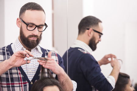 Professional hairdresser cutting hair  for a brunette girl in hairdresser salon.の写真素材
