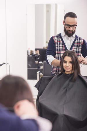 Professional hairdresser making hair for a brunette girl in hairdresser salon.の写真素材