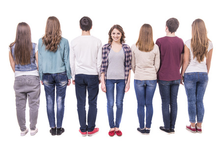 Full length. young group standing with his back to the camera except one girl. isolated on white background.の写真素材