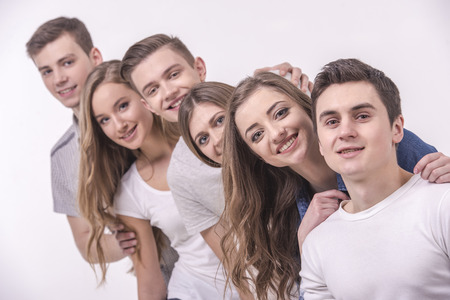 Happy smiling young group looking at camera. isolated on grey background.の写真素材