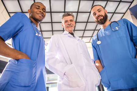 Three handsome male doctors looking at camera in hospital.の写真素材