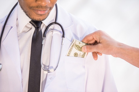 Close-up. Corruption. Male giving bribe doctor. Medicine concept.の写真素材