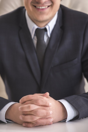 Close-up. Businessman in a suit with his hands clasped in front.の写真素材