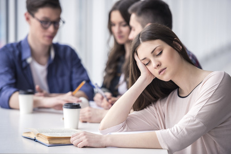 Young female student sleeping during lectures  in a college.の写真素材