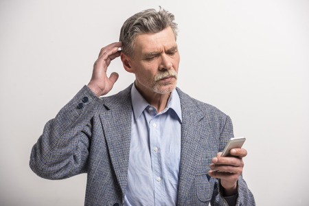 Portrait of a senior man using phone.の写真素材