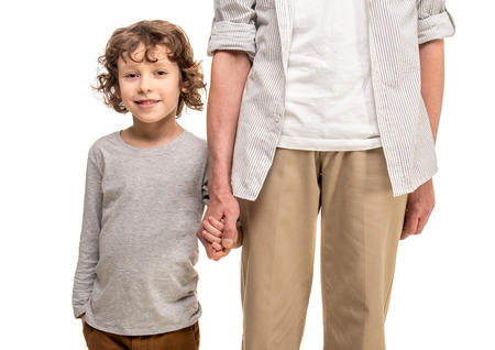 Close-up. Father and son holding hands, isolated a white background.の写真素材