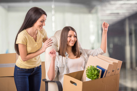 Two adult businesswomen moving into a new office.の写真素材