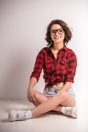 Portrait of smiling young beauty woman sitting on the floor in studio.の写真素材