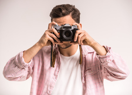 Close-up of a young man taking a picture with an old camera.の写真素材