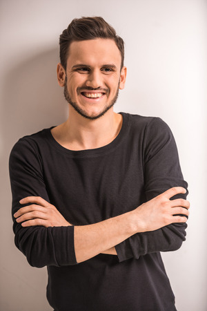 Young, smiling,  handsome man is posing in studio, gray background.の写真素材