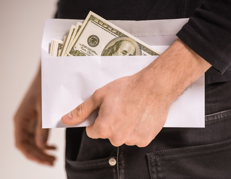Close-up hand of man is holding envelope with money.の写真素材